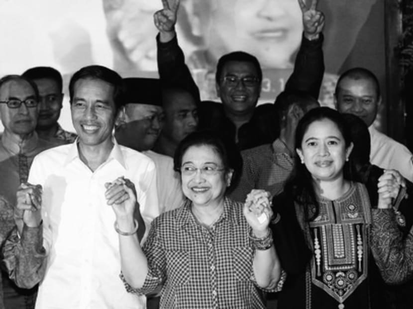 Mr Widodo (left) celebrating his presidential election win with Ms Megawati Sukarnoputri (centre) and her daughter Puan Maharani (right) last July. Early on, Mr Widodo told everyone that a sitting minister would have to relinquish any political party post, but minister Maharani seems to be exempt from the rule. Photo: Reuters