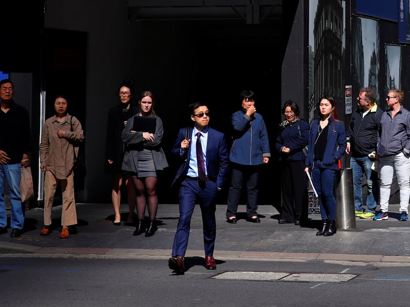 Pedestrians at Sydney's central business district. The author says that an important factor to consider is the cost of living of the country you plan to work in.