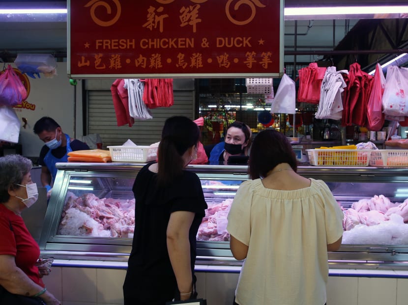 Customers buying chicken from a stall selling fresh poultry at a wet market in Vista Point, Woodlands.