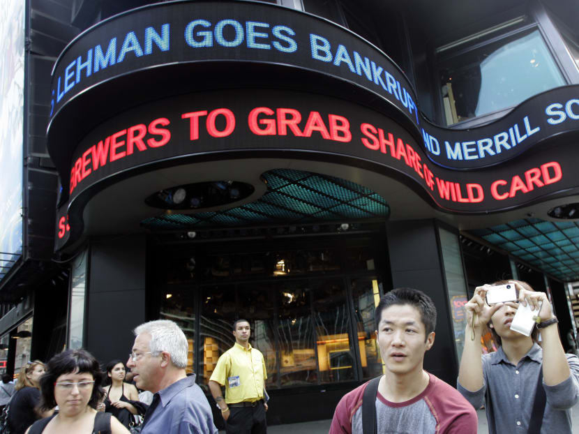 In this Sept 15, 2008, file photo tourists take pictures in New York's Times Square as the days financial news about the bankruptcy of Lehman Brothers is displayed on the ABC news ticker. Photo: AP