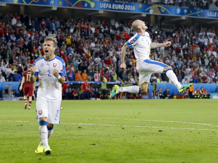 Slovakia's Martin Skrtel (right) leaping in celebration past his teammate Peter Pekarik after the referee blew the whistle to mark their 2-1 win over Russia. Photo: AP