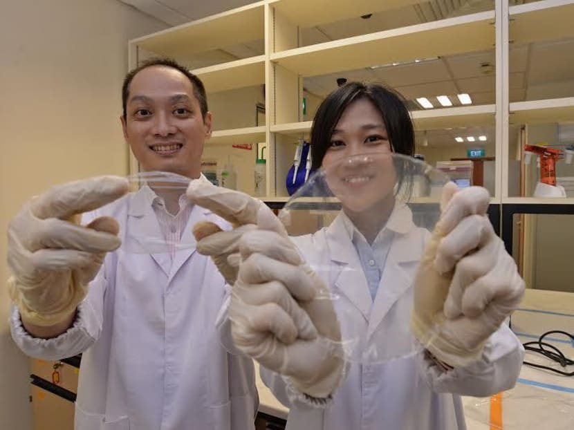Assoc Prof Thian Eng Han (left) and PhD student Ms Tan Yi Min have developed eco-friendly food packaging material. In this photo, they are holding up the chitosan-based GFSE composite film. Photo: Robin Choo