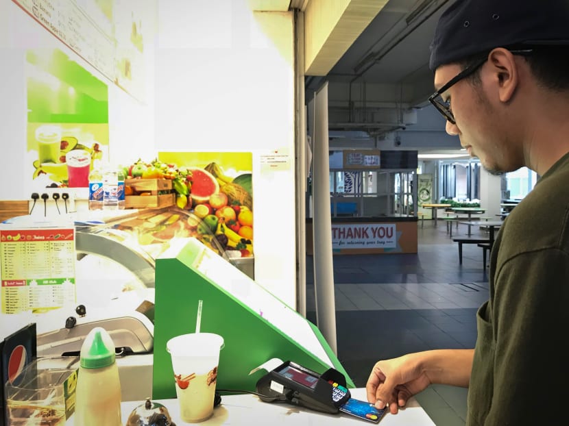 Singapore Polytechnic student Amirul Asyraf, 22, making a NETS payment at a fruit juice stall in Singapore Polytechnic. Photo: Cynthia Choo/TODAY
