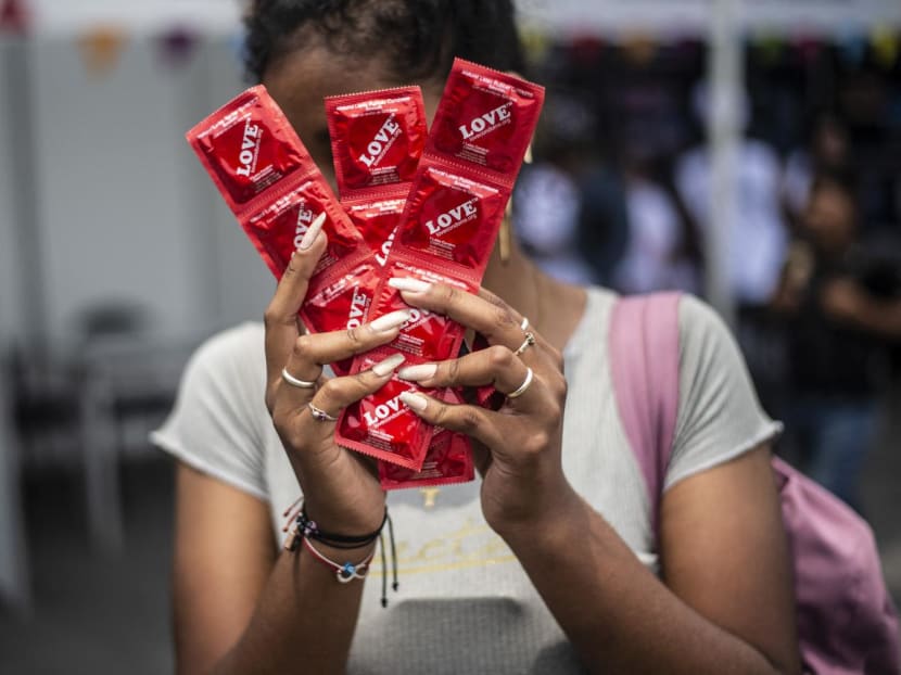 A woman holds condoms during a fair in Lima, Peru, organised by the Aids Healthcare Foundation in 2020.

