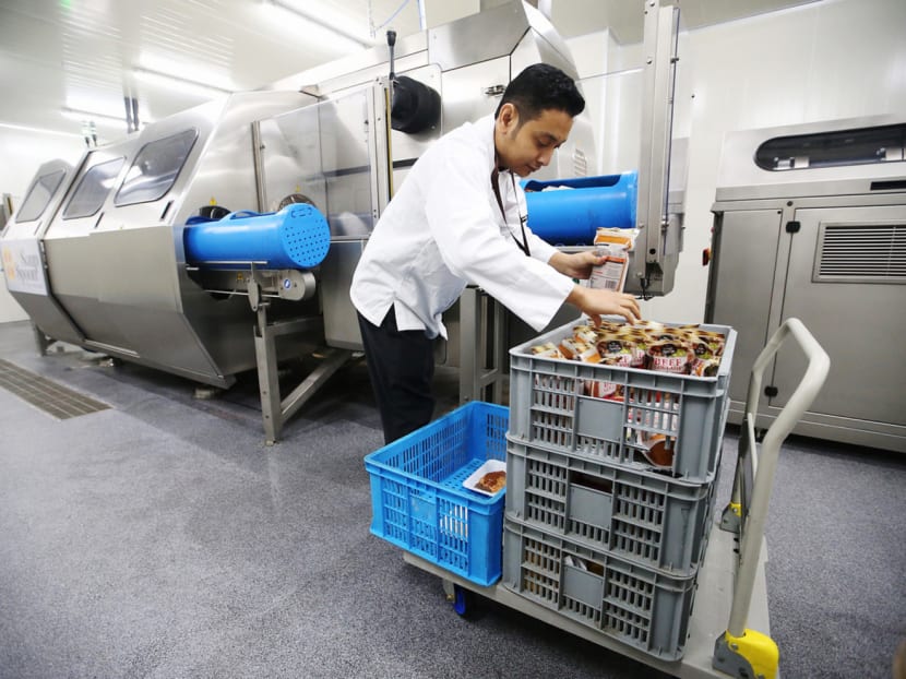 A worker packing products at the new S$70 million integrated food production and services hub by Commonwealth Capital, which will use the 300,000 sq ft facility to service the needs of its 151 cafes and restaurants in 12 countries. Photo: Koh Mui Fong