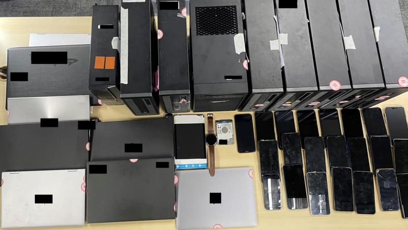 Electronic devices seized during an enforcement operation against a syndicate that brought in migrant workers through illegally obtained work passes. (Photo: Singapore Ministry of Manpower)
