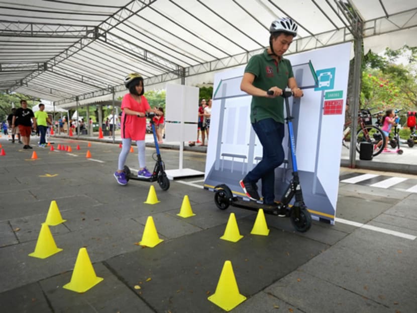 Participants dismount from their personal mobility devices as they pass through a "bus stop" in the circuit of LTA's Safe Riding Programme during February's Car-Free Sunday SG. The programme aims to equip cyclists and personal mobility device users with safe riding skills and the proper use of cycling-related infrastructure. Photo: Nuria Ling/TODAY