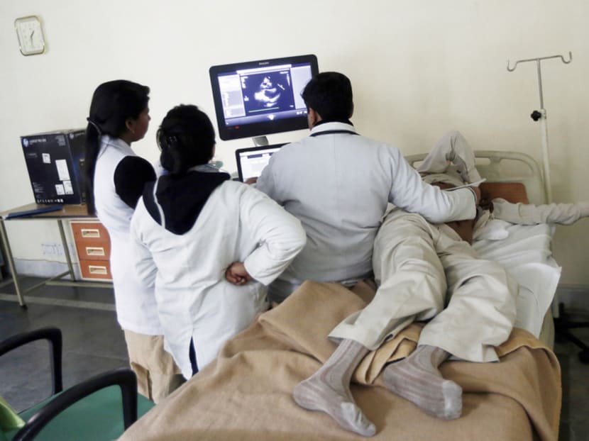 Doctors checking the ultrasound scan of a patient at a hospital in New Delhi. India’s stretched health system will lose about 100 foreign aid agency consultants under changes to government rules. Photo: REUTERS