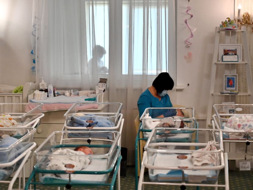 This file photo taken on May 15, 2020 shows a nurse caring for newborn babies at Kiev's Venice hotel, some of the more than 100 babies born to surrogate mothers stranded in Ukraine as their foreign parents cannot collect them due to border closures imposed during the Covid-19 coronavirus pandemic.