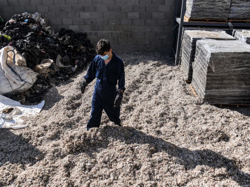 Workers sort through shredded plastic waste at a workshop of the startup company "TileGreen", where it is recycled into eco-friendly interlocking tiles used in outdoor walkways, in the Ashir min Ramadan (10th of Ramadan) industrial city, about 60km east of Egypt's capital, on Dec 8, 2022.