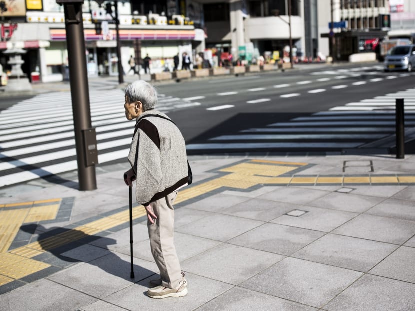 A Japanese elderly woman waits for the traffic light to cross the street in Nagano, northwest of the capital Tokyo on November 7, 2016. Photo: AFP