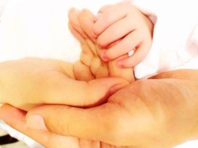 Yang Mi and husband Hawick Lau holds the hand of their baby girl in a photo posted by Yang Mi on June 2, 2014. Photo: Channel NewsAsia