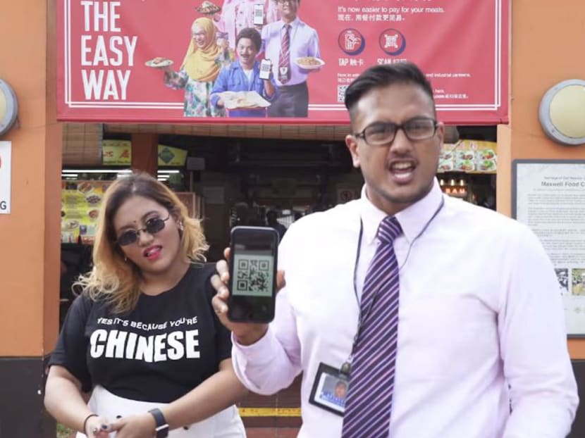 A rap video posted on Facebook by Preeti Nair (left) featuring rapper Subhas Nair (right) was directed against an e-payment advertisement (in the background).