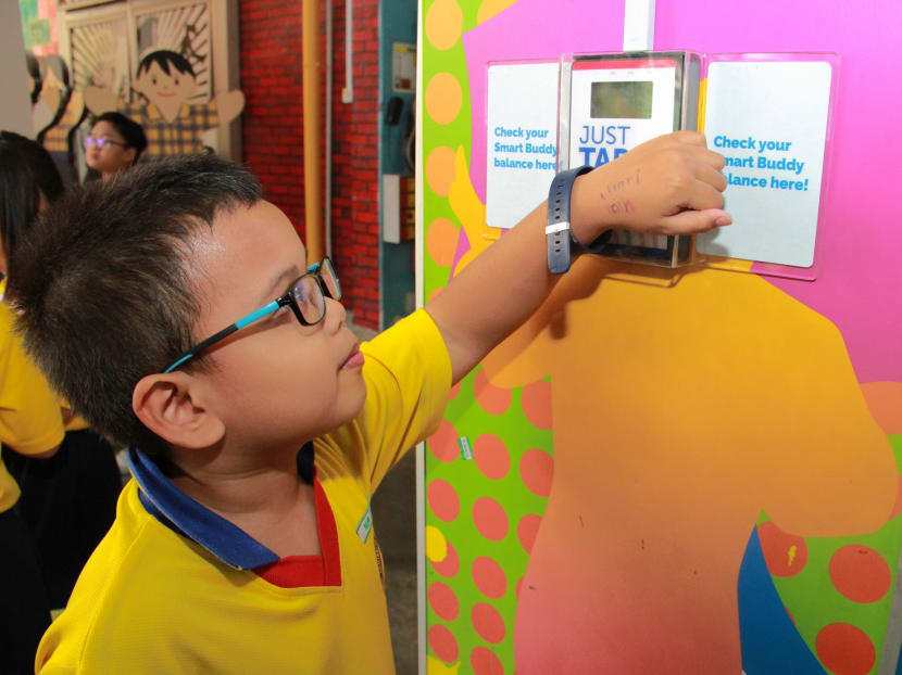 An Admiralty Primary School student scanning his Smart Buddy watch at a kiosk to check the balance of his pocket money for the day. Photo: Esther Leong/TODAY