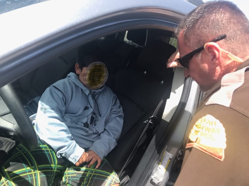 A photo released by the Utah Highway Patrol shows an officer speaking to a 5-year old boy that was pulled over after driving down the highway in Weber County near Ogden, Utah, on May 4, 2020.