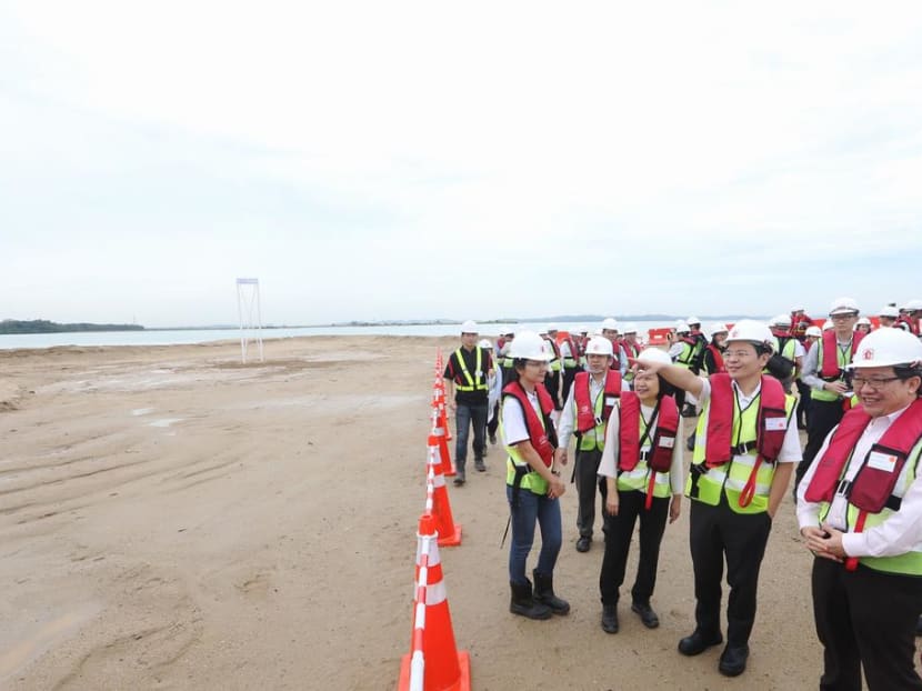 Officials including National Development Minister Lawrence Wong (second from right) during a 2016 visit to the site of the polder being built on Pulau Tekong, which is about the size of two Toa Payoh towns. Construction is still under way.