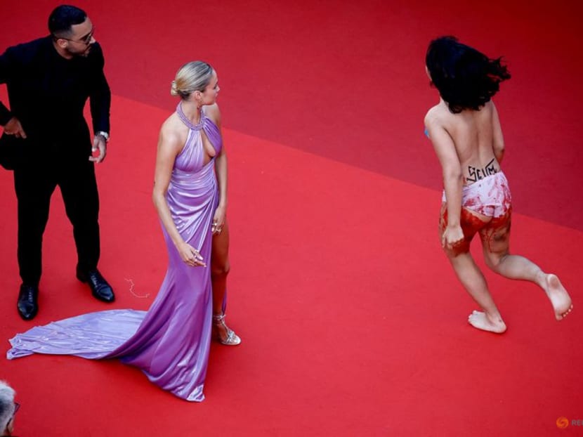 Protester painted in Ukraine colors ejected from Cannes red carpet Protester painted in Ukraine colors ejected from Cannes red carpet
