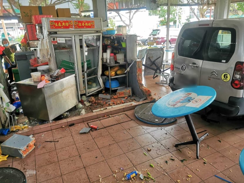 The van reversed more than 5m into the coffee shop, smashing through a brick divider and pinning a woman at a fruit stall that she was tending, an eyewitness said.