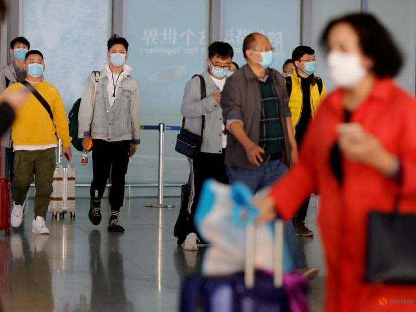 FILE PHOTO: People wearing protective face masks arrive at Capital Airport, following an outbreak of the coronavirus disease (COVID-19), in Beijing, China, November 5, 2020. REUTERS/Thomas Peter