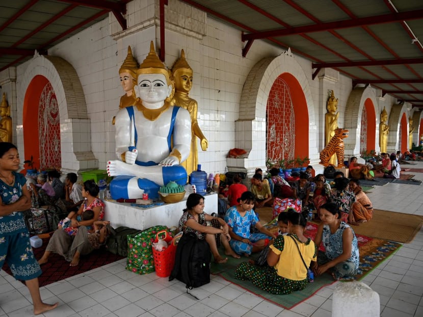People shelter at a monastery in Sittwe town in Myanmar’s Rakhine state on May 12, 2023, ahead of the expected landfall of Cyclone Mocha