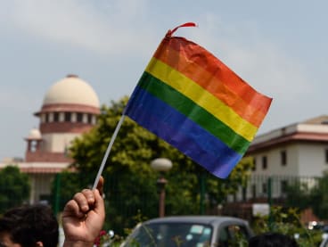 An Indian member of the lesbian, gay, bisexual, transgender (LGBT) community waves a flag outside the Supreme Court building as crowds gathered to celebrate the decision to strike down the colonial-era ban on gay sex in New Delhi on Sept 6, 2018.