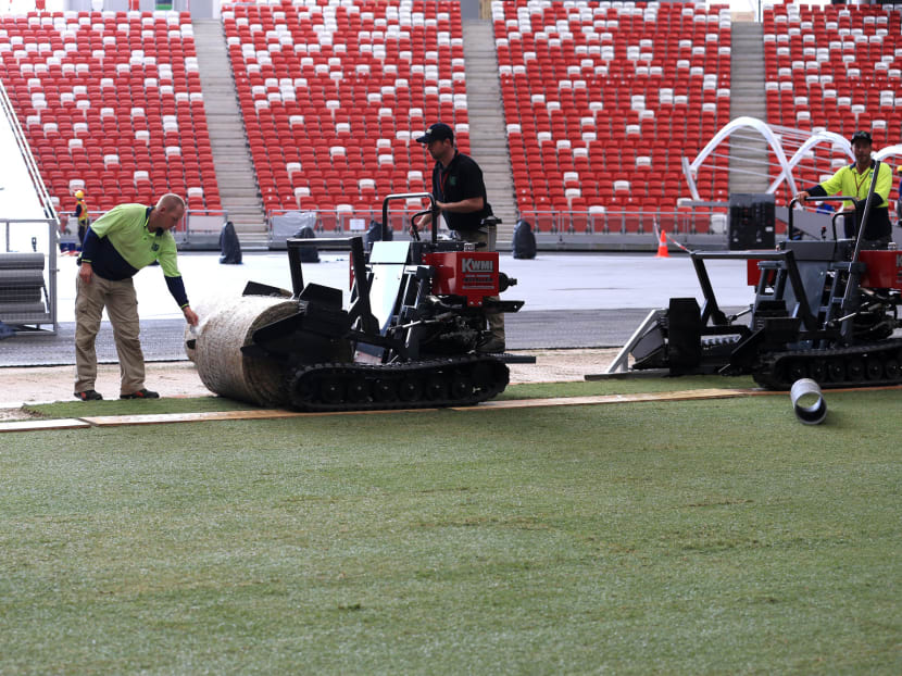 Workers from HG Sports turf laying the new turf at National Stadium, Singapore Sports Hub on 19 May 2015. Photo: Wee Teck Hian
