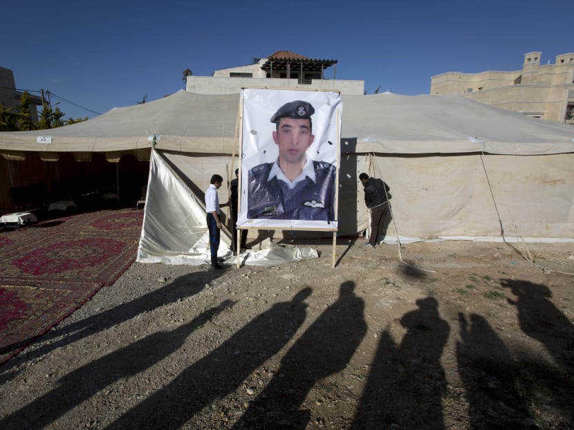 A banner with a picture of Jordanian pilot, Lt. Muath al-Kaseasbeh, who is held by the Islamic State group militants, is being raised by workers near a tent prepared for receiving supporters, in Amman, Jordan, Friday, Jan. 30, 2015. Photo: AP