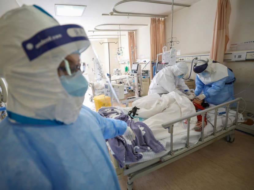 Medical workers in protective suits attend to a patient inside an isolated ward of Wuhan Red Cross Hospital in Wuhan, Hubei province, China, Feb 16, 2020.