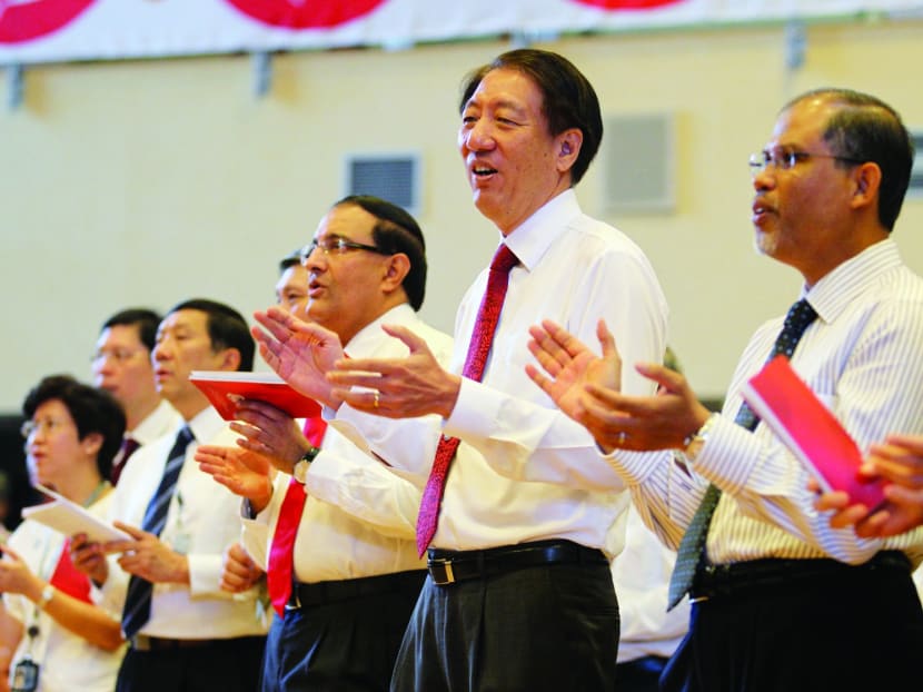 Deputy Prime Minister Teo Chee Hean (centre) singing along during a performance at the Home Team National Day Observance Ceremony, with Senior Minister of State for the Ministry of Home Affairs and Ministry of Foreign Affairs Masagos Zulkifli (right), and Minister in the Prime Minister's Office S Iswaran (third from right). Photo: Syafiqah Hamid