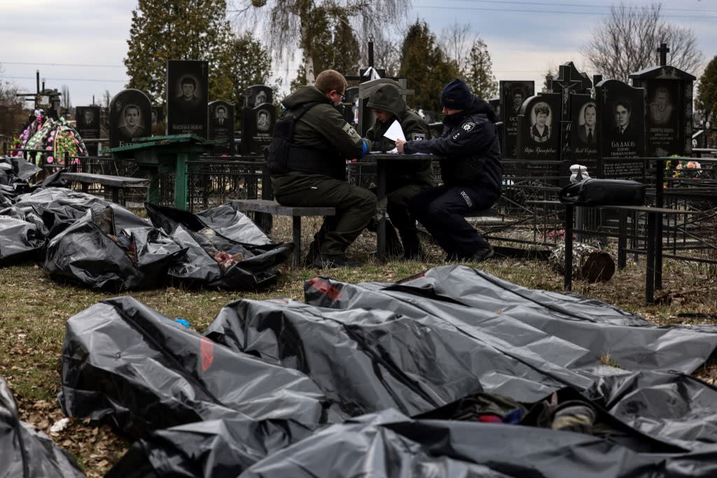 Bodies are lined up for identification by forensic personnel and police officers in the cemetery in Bucha, north of Kyiv, on April 6, 2022.
Bodies are lined up for identification by forensic personnel and police officers in the cemetery in Bucha, north of Kyiv, on April 6, 2022.
