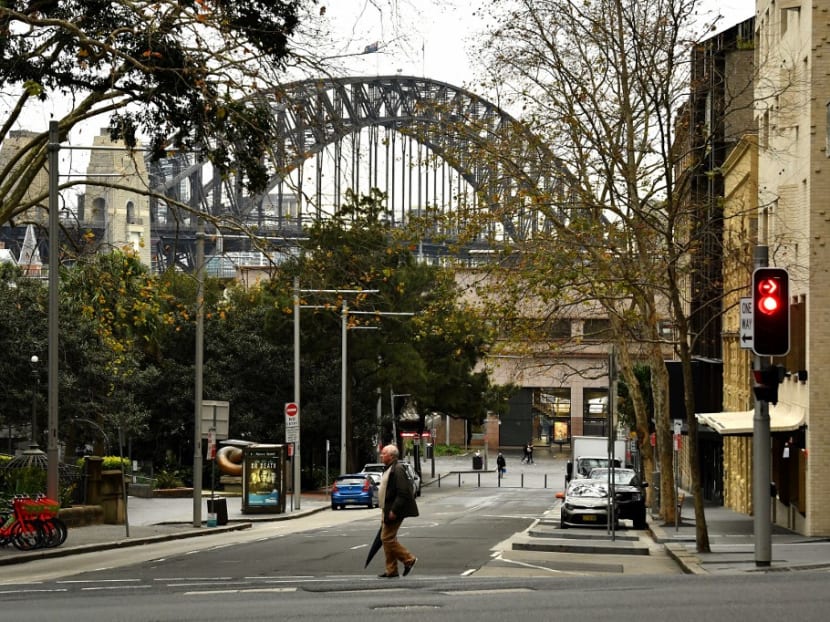 A lone pedestrian walks throught the quiet streets of the central business district of Sydney on July 23, 2021, amid a coronavirus outbreak that state leaders said has become a "national emergency".