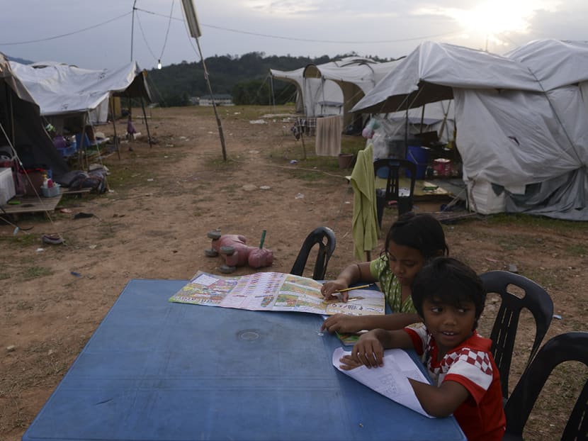 Children doing their homework outdoors in Bandar Utama, Gua Musang, Kelantan. Their families are victims of the December flooding and are supposed to be living temporarily in tents. Photo: The Malaysian Insider