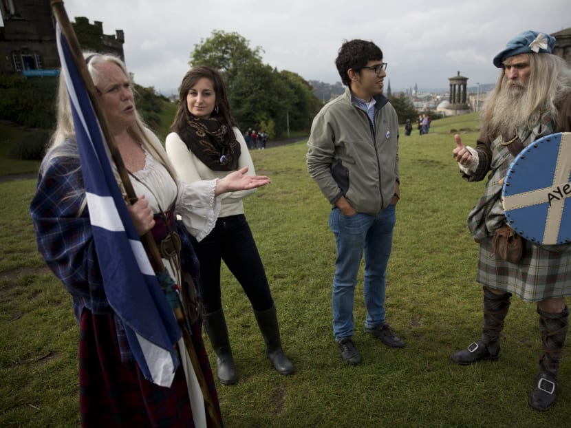 Scottish independence referendum Yes campaign supporters and members of a Scottish historical re-enactment group Ed Hastings, right, and his wife Sandy Hastings, left, wearing historical Scottish outfits chat to a group of Catalans including Aleix Sarri, second right, who are visiting Scotland to follow the referendum on Calton Hill, in Edinburgh, Scotland, Tuesday, Sept 16, 2014.  Photo: AP