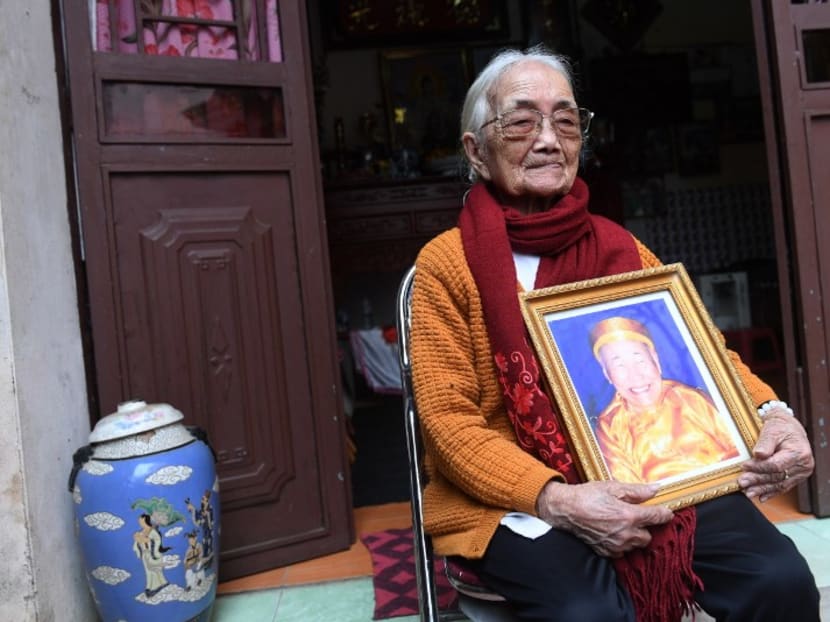 Ms Nguyen Thi Xuan with a framed portrait of her Japanese husband. Photo: AFP