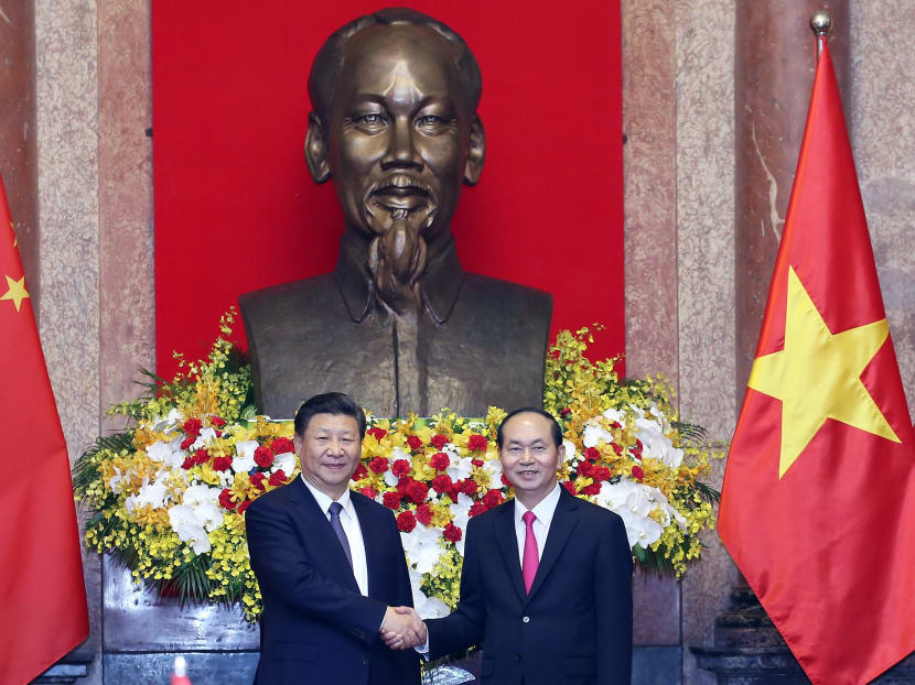Chinese President Xi Jinping (L) shakes hands with Vietnamese President Tran Dai Quang (R) at Presidential Palace in Hanoi. Over five days in Vietnam and Laos, Mr Xi played two seemingly disparate roles: defender of global commerce and torchbearer for international communism. Photo: AFP