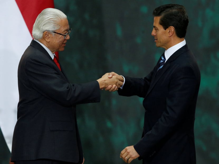 Singapore's President Tony Tan Keng Yam shakes hands with Mexico's President Enrique Pena Nieto after delivering a speech to the media, during an official welcoming ceremony, at the National Palace in Mexico City, Mexico June 10, 2016. Photo: Reuters