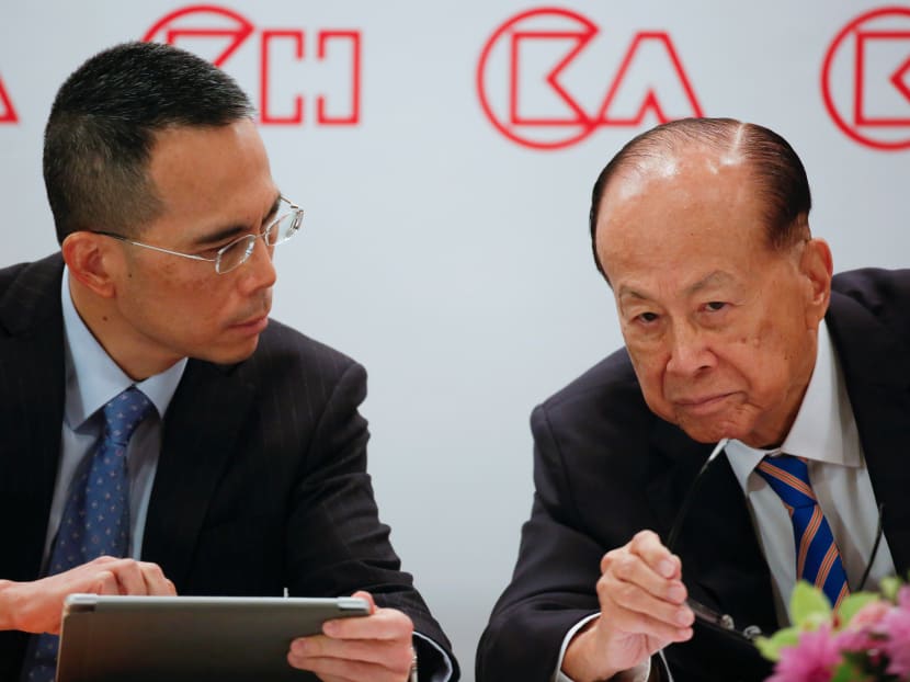 Hong Kong tycoon Li Ka-shing listens to his son Victor Li during a news conference in Hong Kong in March.
