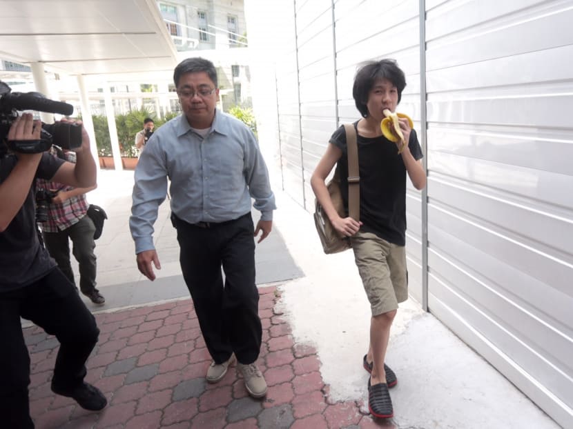 Amos Yee eating a banana as he enters the State Courts with his father for his pre-trial conference on April 17, 2015. Photo: Jason Quah