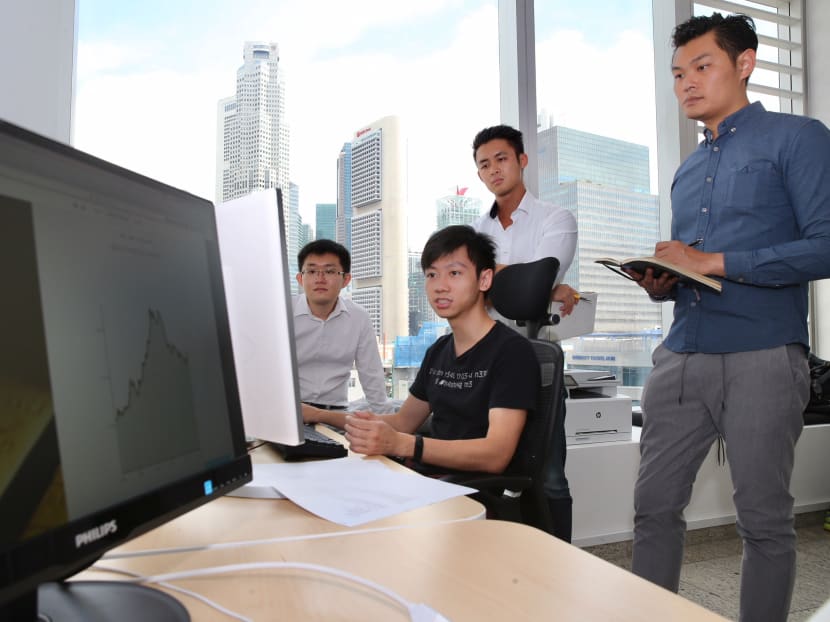 (From left) Mr Teo Chen Shien, Company Counsel, DigixGlobal; Mr Vu Nguyen, Developer, DigixGlobal; Mr Shaun Djie, Co-Founder & COO, DigixGlobal and Mr KC Chng, Co-Founder & CEO, having a work discussion in the DigixGlobal office on November 2, 2017. Photo: Koh Mui Fong/TODAY