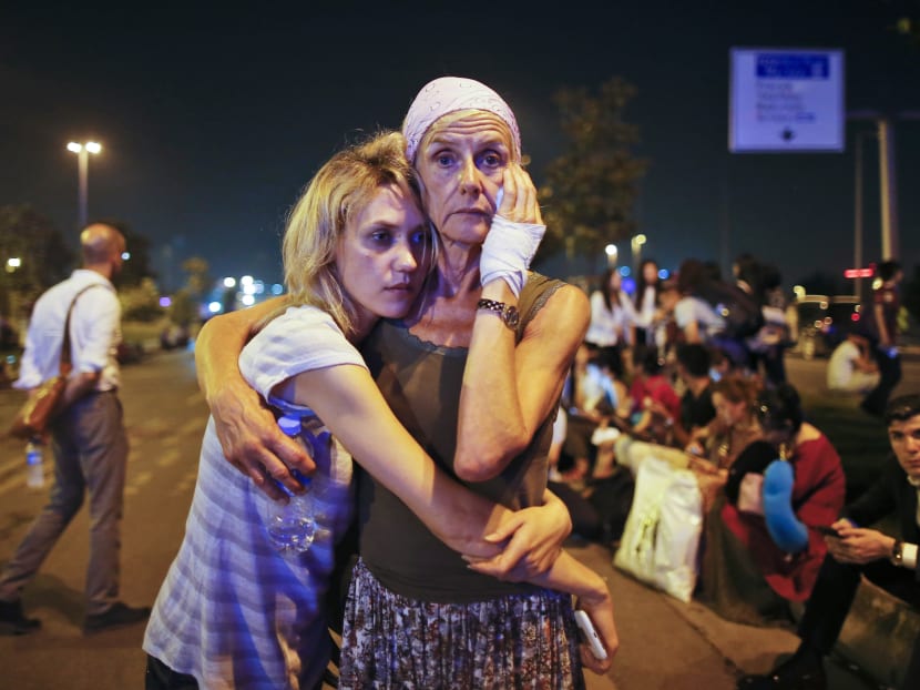 Passengers embrace each other as they wait outside Istanbul's Ataturk airport, early Wednesday, June 29, 2016 following their evacuation after a blast. Photo: AP