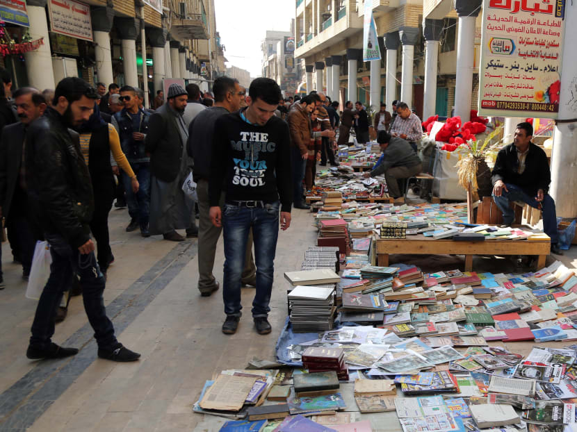 In this Friday, Jan. 23, 2015 photo, Iraqis look at books on al-Mutanabi Street, home to the city's book market in central Baghdad. Photo: AP
