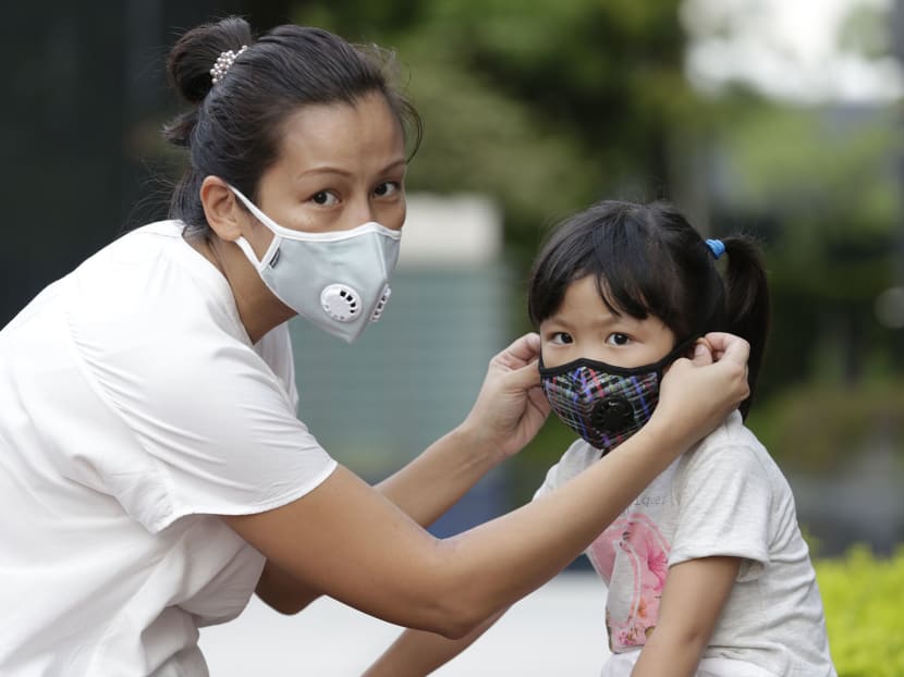 Ms Adelene Koh helping her daughter put on a face mask. Photo: Wee Teck Hian/TODAY