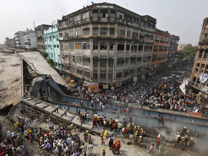 Firefighters and rescue workers search for victims at the site of an under-construction flyover after it collapsed in Kolkata, India, March 31, 2016. Photo: Reuters