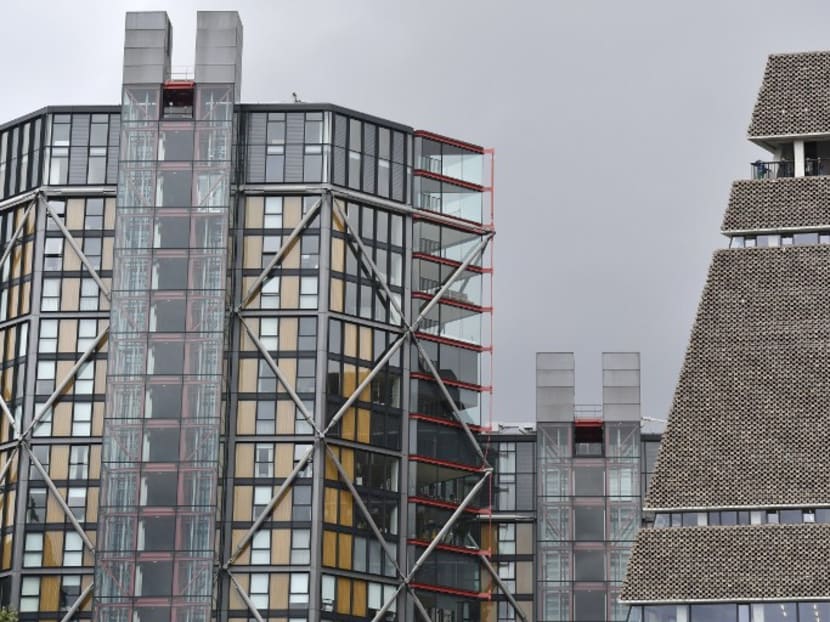 Visitors stand looking out from the viewing gallery at the top of the Tate Modern's Switch House (right) extension and nearby residential blocks of flats (left) in London. Photo: AFP