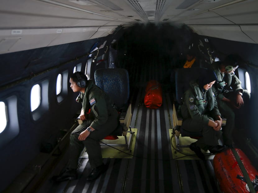 Crew members from the Royal Malaysian Air Force look through windows of a Malaysian Air Force CN235 aircraft to find the missing Malaysia Airlines flight MH370 in the Straits of Malacca in this March 13, 2014 file photo. Photo: Reuters