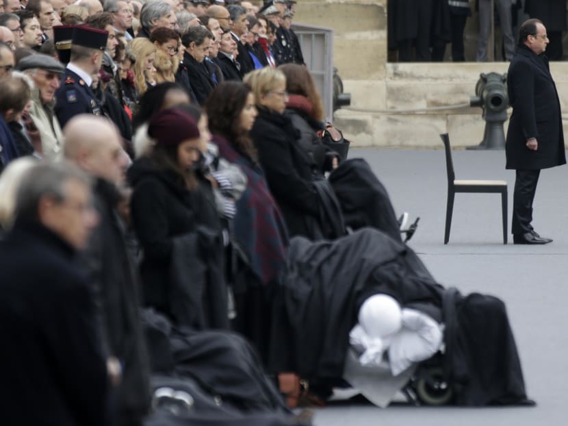 French President Francois Hollande, right, attends a ceremony to honor the 130 victims killed in the Nov. 13 attacks, in the courtyard of the Invalides in Paris, Friday, Nov. 27, 2015. Photo: AP