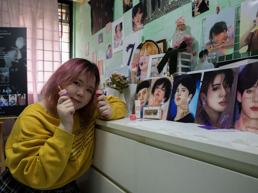 Ms Ng Kwok Ching poses with the BTS portraits she drew and her Loveholic Beauty cosmetics at her home in Jurong West on Dec 22, 2020.
