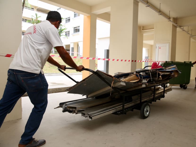 Photo of the day: Pasir Ris-Punggol town council cleaners clearing up the cladding of an HDB block at Pasir Ris, which fell off on Monday (June 18).