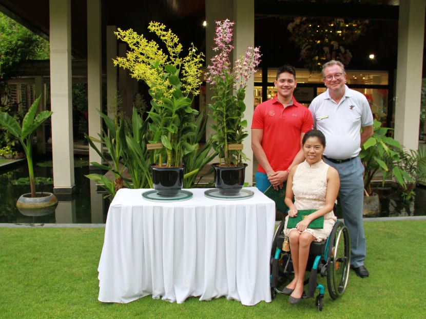 Joseph Schooling and Yip Pin Xiu presented with their orchids by Dr Nigel Taylor, Group Director of the Singapore Botanic Gardens. Photo: Esther Leong/TODAY