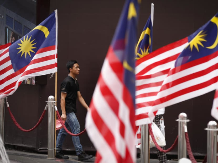 A man walks by displays of Malaysian national flags outside a shopping mall in Kuala Lumpur, Malaysia. AP file photo